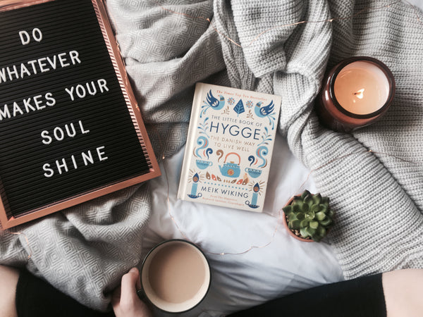 Hygge book on blanket with scented candle and pegboard