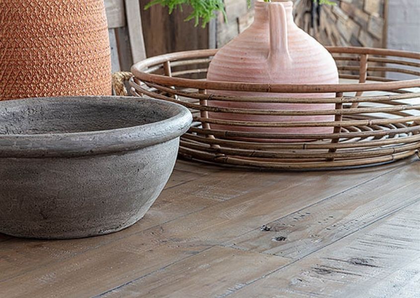 Close up of reclaimed wood dining table with terracotta and earthenware vases