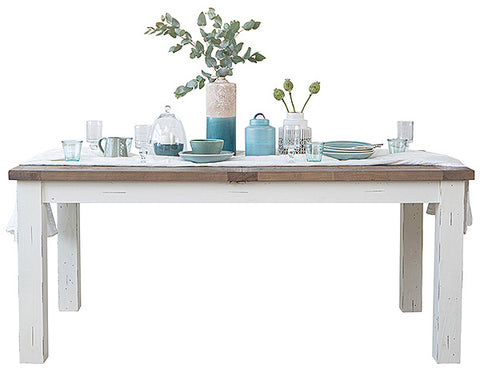 White painted wooden dining table with decorative items placed on top
