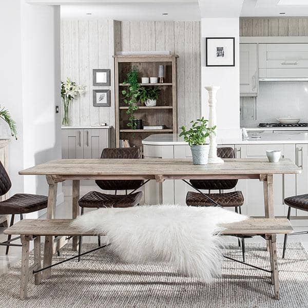 Farmhouse wooden dining table with wooden chairs in traditional kitchen