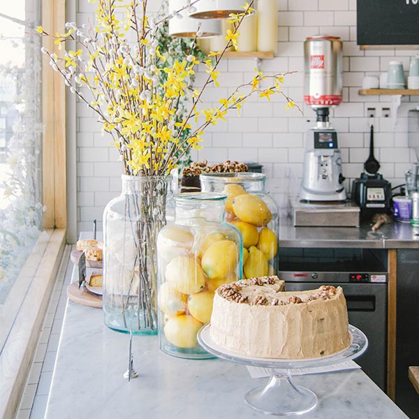 Yellow Flowers on Table with Lemons and Cake