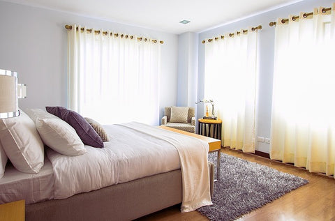 bed in bedroom with large windows at modish living