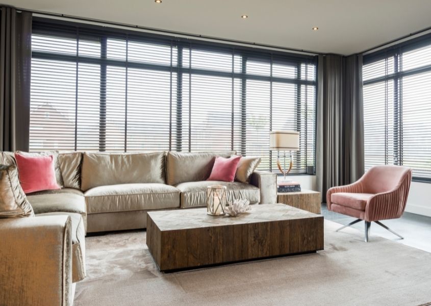 large silver corner sofa with pink armchair and industrial coffee table