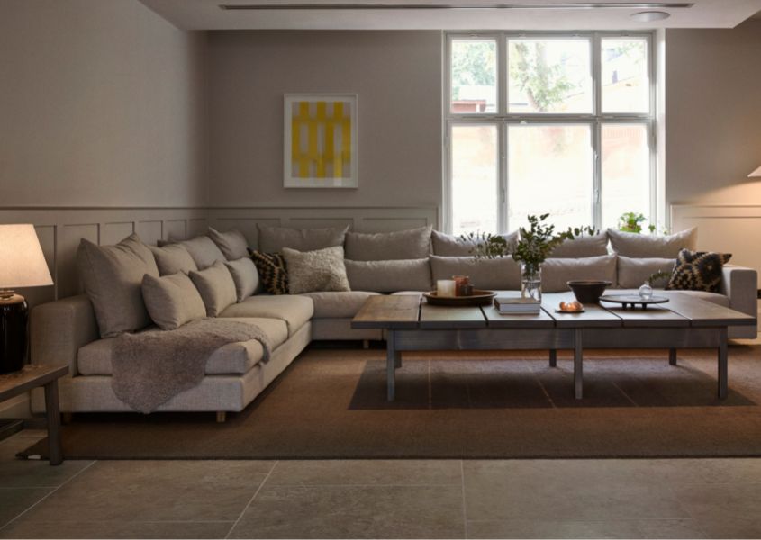 lounge area in hotel with large corner sofa and wooden coffee table